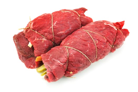Beef roulade raw,wrapped meat dish on a white background