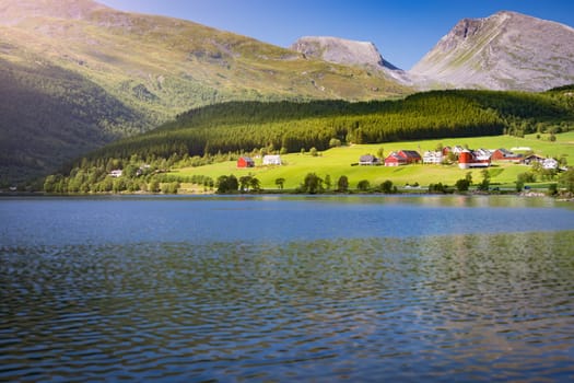 Norway country houses. Lake and meadows. Reflection in water. Nordic, Scandinavia, Europe travel