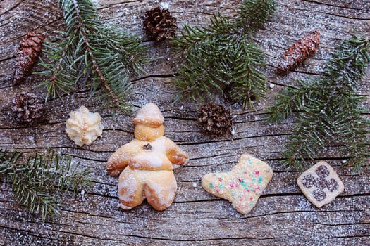 A Santa Claus and cookies made of dough. Christmas decoration on wooden background