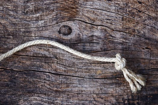 Knotted rope on wooden surface. A rope with a knot on a wooden surface