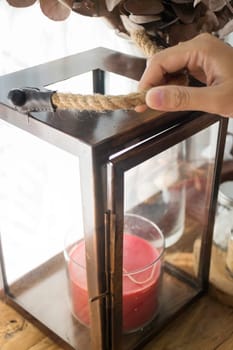 Hand on red aroma candle in wooden box, stock photo