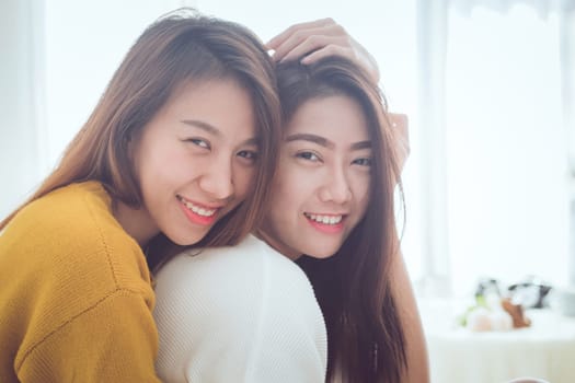Lovely lesbian couple together concept. Couple of young asian women hugging in bed room with happiness moment.