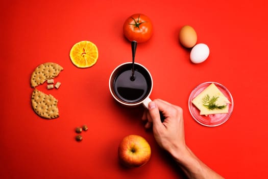 Man holding a Cup of coffee surrounded by different food on a colored background
