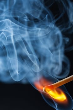 Inflaming match with blue smoke
