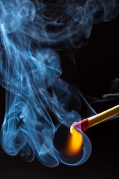 Burning match with blue smoke