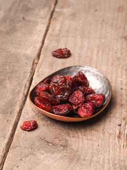 Delicious dried cranberries on a rustic wooden table, healthy food concept