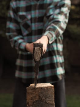 Close up shot of a man cutting fire wood, selective focus on the axe