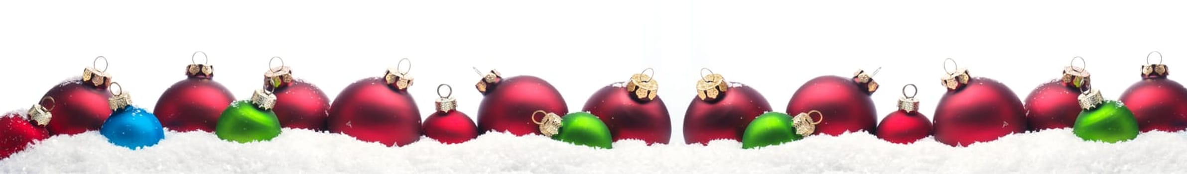 Colorful Christmas baubles in row in snow on a white background
