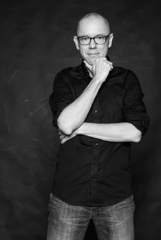 Studio recording of a man with crossed arms against a dark background