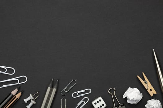 Office accessories on black paper background. Minimal style. Copy space. Top view