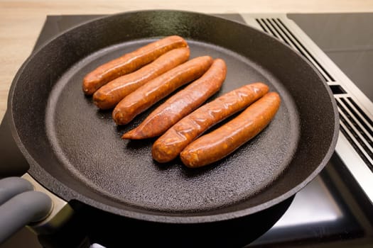 Merguez sausages made from lamb and beef in a frying pan made of cast iron