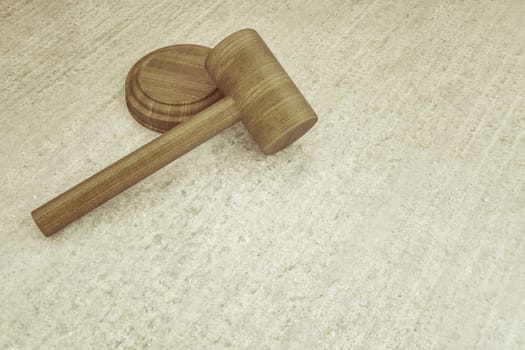 3d illustration of a wooden hammer on a concrete board