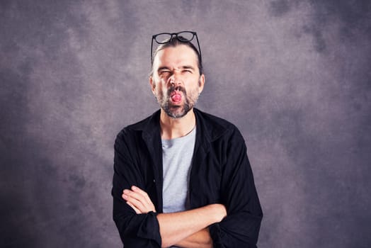 young man looking cheeky in to the camera and showing tongue