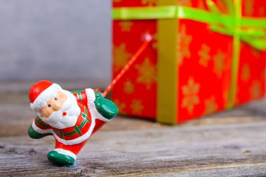 little Santa Claus pulling big red gift box