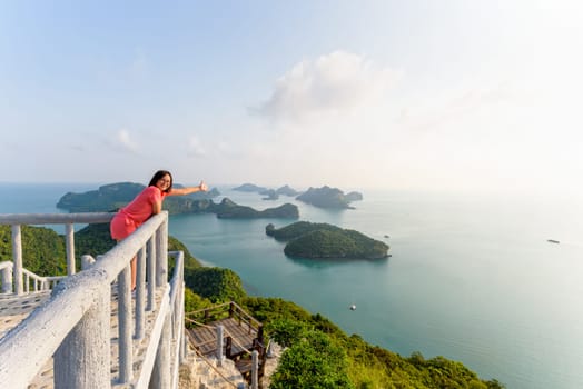 Woman tourist on the balcony is peak view point of Ko Wua Ta Lap island and beautiful nature landscape during sunrise over the sea in Mu Ko Ang Thong National Park, Surat Thani, Thailand