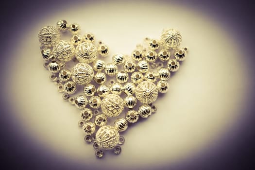 selection of different silver beads shaped into a heart
