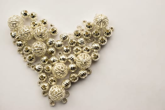 selection of different silver beads shaped into a heart