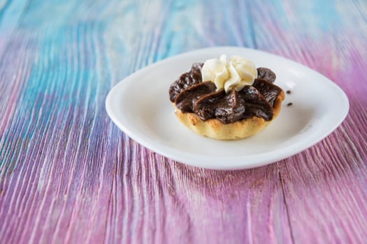 Tasty mini cake with chocolate on a color gradient background
