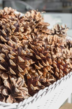 Wicker basket filled with pine cones. Close up. Shallow depth of field.