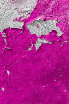 Old pink wall with the peeled-off paint. It can be used as background.