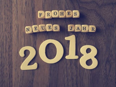 German happy New Year concept with wooden dices on an office table, vintage color stylized