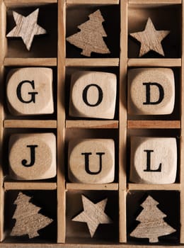 Scandinavian Merry Christmas with wooden dices and the words God Jul