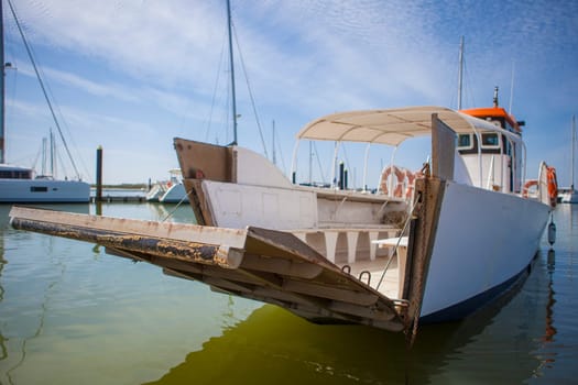 Ferry approaching with open ramp to El Rompido Marina. This little boat only for passengers cross Piedras River to get Atlantic Beach of La Flecha, Cartaya, Huelva, Spain