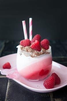 Delicious layered dessert in a glass with raspberry and chocolate