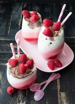 Delicious layered dessert in a glass with raspberry and chocolate
