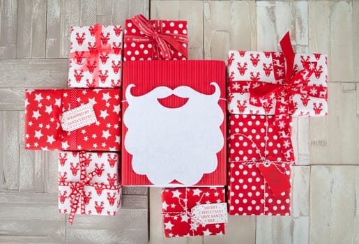 Red and white wrapped gifts for Christmas on wooden background