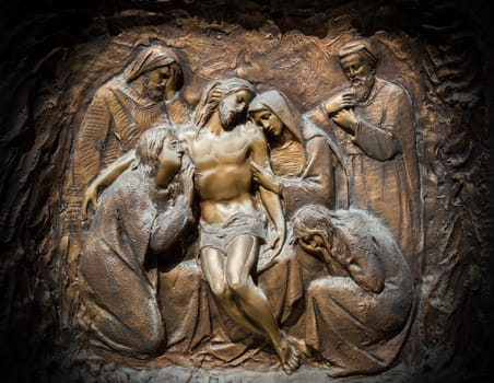 Bronze wall engraving scene depicting the Lamentation of Christ