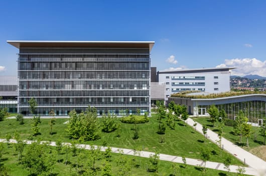 Bergamo, Italy - modern hospital with blue sky, surrounded by trees