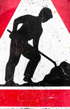 Old roadworks sign, under construction. Grungy warning red road sign, triangle shape with red border, working man isolated on a white background