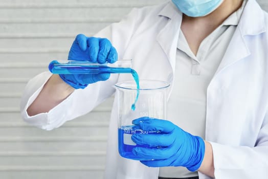science laboratory researcher perform test with blue solution in the lab