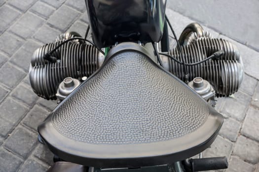 Old motorcycle vintage leather saddle over pavement background