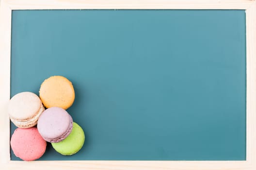 Macarons on a green chalkboard close up