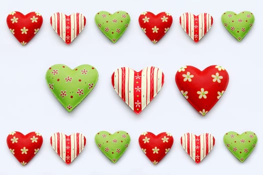 Many colorful hearts on a white background. Red-green metal hearts