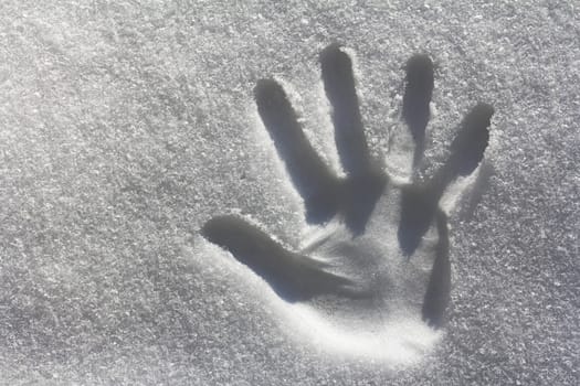 A handprint in the snow. Imprint from one hand in the cold snow