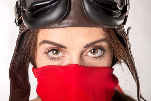 Beautiful girl with freckles wearing helmet, goggles and a red scarf