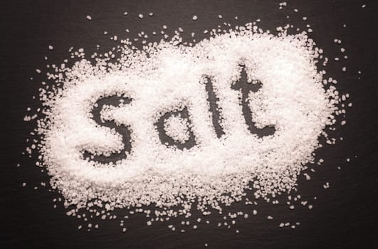 Organic salt on a dark slate board, food concepts