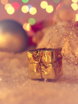 Golden gift box with Christmas decoration in snow