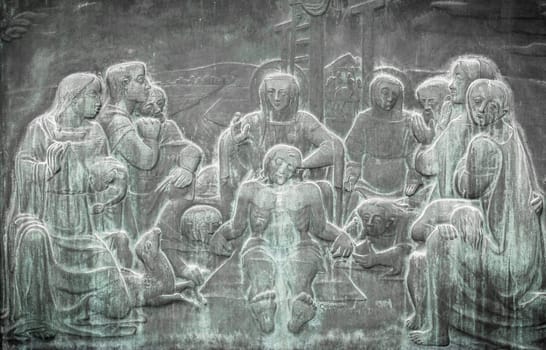 Stone wall engraving scene depicting the Lamentation of Christ