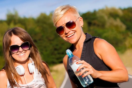 Two young fitness girls outdoor portrait in summer time