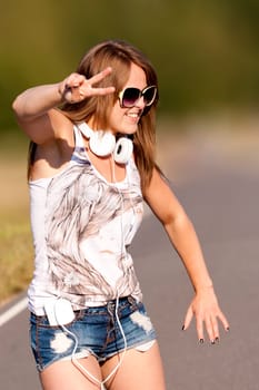 A young pretty and happy girl dancing outdoor in the summer time