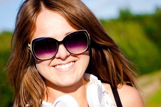 Nice young fitness girl portrait with sunglasses and earphones