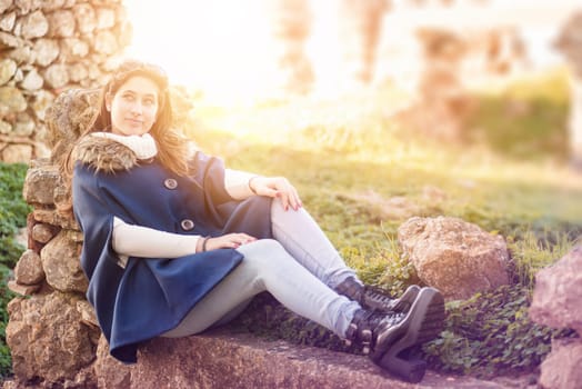 Beautiful happy young girl posing outdoors amongst ruins in beautiful light
