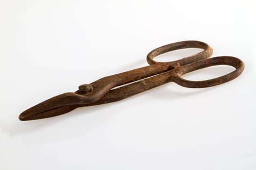 Old rusty scissors on a light background