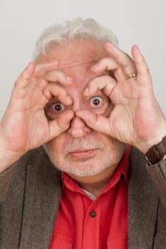Senior holds fingers around his eyes - symbolism for the future and vision