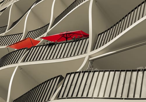 Facade of a residential building with two red umbrellas
