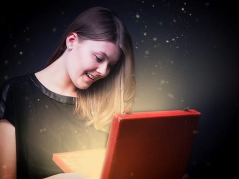 Beautiful young woman with a magical gift box